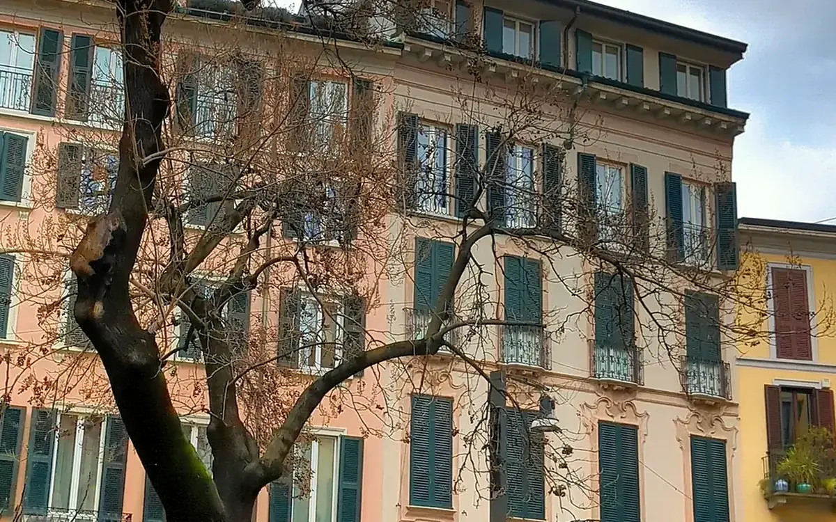 A residential façade in Brera, with balconies and green shutters